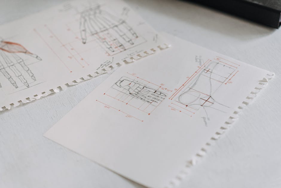 Close-up of detailed technical drawings on neatly arranged white paper sheets, highlighting design concepts.