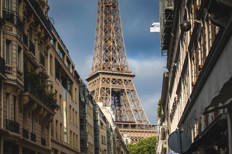 A picturesque street view of the iconic Eiffel Tower surrounded by Parisian buildings.