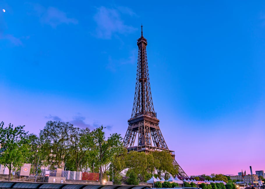 Stunning view of the Eiffel Tower at twilight, Paris bathed in vivid pink and blue hues.